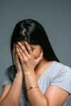 woman hiding her face in her hands